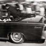 image for Secret Service agent Clint Hill jumps aboard the limousine to act as a protective shield for JFK.