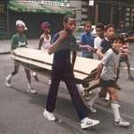 image for Kids carrying cardboard for breakdancing in New York City (1983)