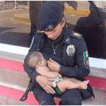 image for A police woman breastfeeds a baby from a misplaced family during Acapulco rescue efforts.