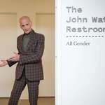 image for John Waters standing outside the restrooms dedicated to him at the Baltimore Museum of Art