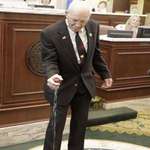 image for Danny Hodge, a former boxer and wrestler, squeezes apple juice with one hand at 80 years old.