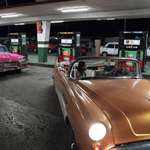 image for Cubans in vintage cars leave the gas station after filling up the tank in Havana