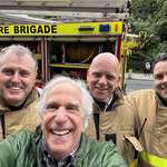 image for Henry Winkler taking a photo with firefighters in Dublin after his hotel was evacuated