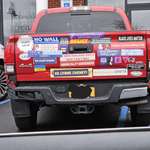 image for A red truck with stickers on the back.