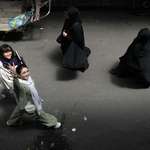 image for Woman without wearing her mandatory headscarf flashes a victory sign