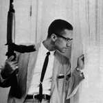 image for Malcolm X holding a Rifle while guarding his family, 1964.