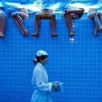 image for Waitress wearing a bathrobe walks by mannequins at a Beijing restaurant set to look like a bathhouse