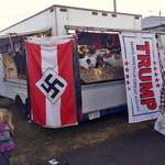 image for A man selling political flags and merchandise out of a trailer at a county fair.