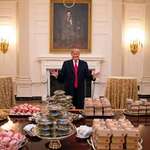 image for Donald trump next to the big fast food feast he set up for the Clemson University Tigers in 2019.