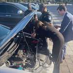 image for Alexandria Ocasio-Cortez helping to jump start a car on Capitol Plaza