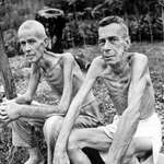 image for Lee Rogers & John Todd, sit outside of a Japanese concentration camp after its liberation. (1945)