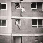 image for Children bouncing on worn out mattresses in England, 1980s.