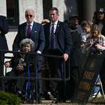 image for President Joe Biden waits in line with voters outside a polling station in New Castle, Delaware.