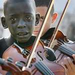 image for kid playing the violin in his teacher's funeral. that teacher helped him escaped poverty & violence