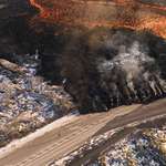 image for A person standing in front of lava flowing from the current eruption in Iceland