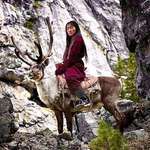 image for A young woman belonging to the Tsaatan tribe in Mongolia, Central Asia, riding a deer.