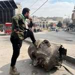 image for Syrian man stepps on the statue of ex syrian dictator hafez al assad