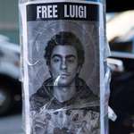image for A poster of Luigi Mangione hanging outside the Hilton Midtown Hotel in New York