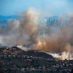 image for The Pacific Palisades burns with Los Angeles in the background
