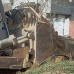 image for Rachel Corrie, 23, stands between a bulldozer and a house on March 16, 2003.