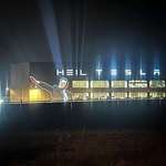 image for Elon's nazi salute and the word "heil" projected onto Tesla's Berlin factory