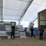 image for Workers unload mattresses at a temporary shelter to receive Mexicans deported from the U.S.
