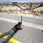 image for Militia member aims his rifle at federal agents during standoff near Bunkerville, Nev. in 2014.