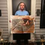 image for Me holding my latest painting in front of my home at night. Acrylic on paper. June 2025