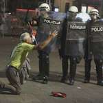 image for An elderly man falls to his knees, begging police to stop the violence against student protesters