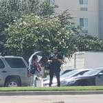 image for A cop in Dallas, TX writing a ticket to a woman selling flowers at an intersection