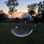 image for A photo I got while blowing bubbles with my daughters at sunset, with our fire reflected in it (OC)
