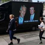 image for People walk past a mobile ad van that displays a photograph of the US President Trump & his friend.