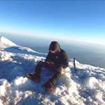 image for Me on the summit of Mt. Rainier. I’m writing an entry in my diary in case I die on the descent