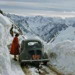 image for 1956, a woman steps outside of her car on a snowy road in the Pyrenees, France. Photo Justin Locke.