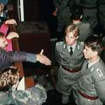 image for A Hand Reached Across History as East German Guards Reject a Berliner at the Fall of the Wall