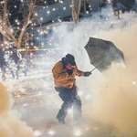 image for A protester in Minneapolis attempting to protect themselves against munitions and pepper balls