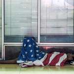 image for “American Dream” Man sleeping on sidewalk under American flag. [OC]