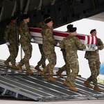 image for An Army carry team moves a flag-draped transfer case with the remains of Sgt. Declan Coady, 20.
