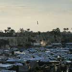image for Israeli bomb mid-air as it falls toward a densely packed tent camp for displaced Palestinians