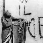 image for Indian soldier holding the nazi swastika flag after surrender of German troops in Italy