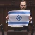 image for Far-right Polish lawmaker Konrad Berkowicz holding up a paper Israeli flag with a swastika