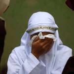 image for A woman cries after being caned during a public punishment for violating sharia law in Indonesia
