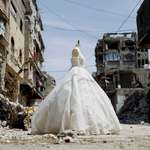 image for A wedding dress on display outside a shop in Gaza as brides turn to reused gowns amid shortages