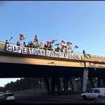 image for cape town activists with a massive drop over the highway in support of gaza.
