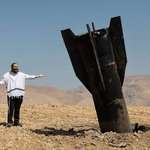 image for A man looking at the remains of Iranian missile [Abir Sultan/EPA]