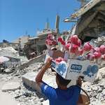 image for A young street vendor selling traditional candy apples through the destruction in Gaza.