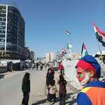 image for A clown walking through a tent camp, Gaza